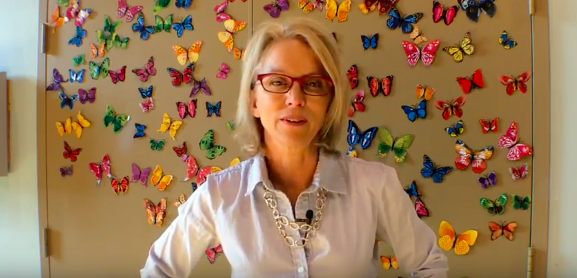 Liz in front of butterfly wall