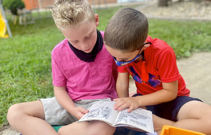 boys reading outside